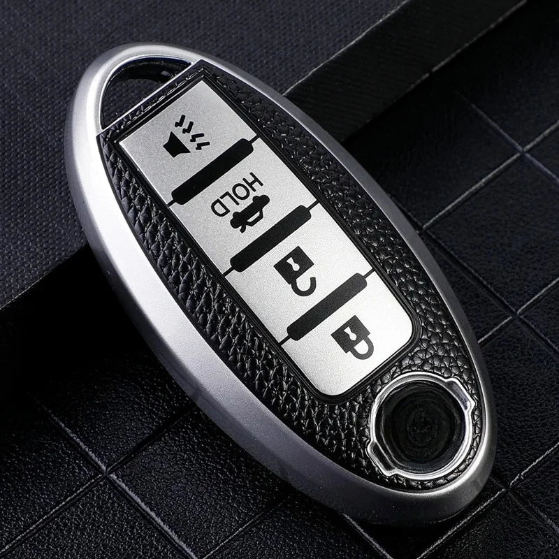 A silver car key fob cover with a textured black surface and multiple buttons.