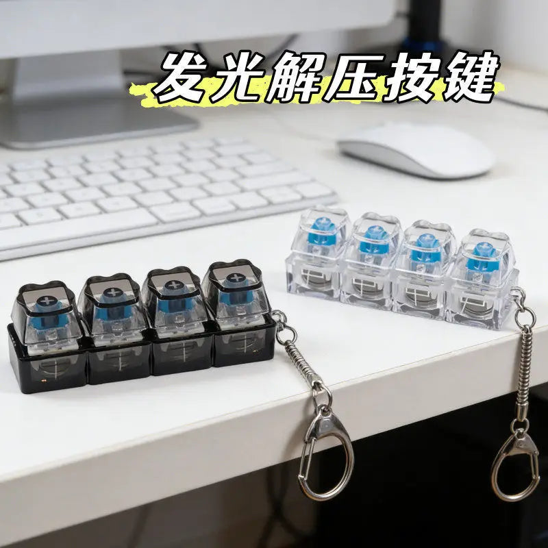 A set of illuminated mechanical keyboard keychains with blue lights displayed on a white desk.