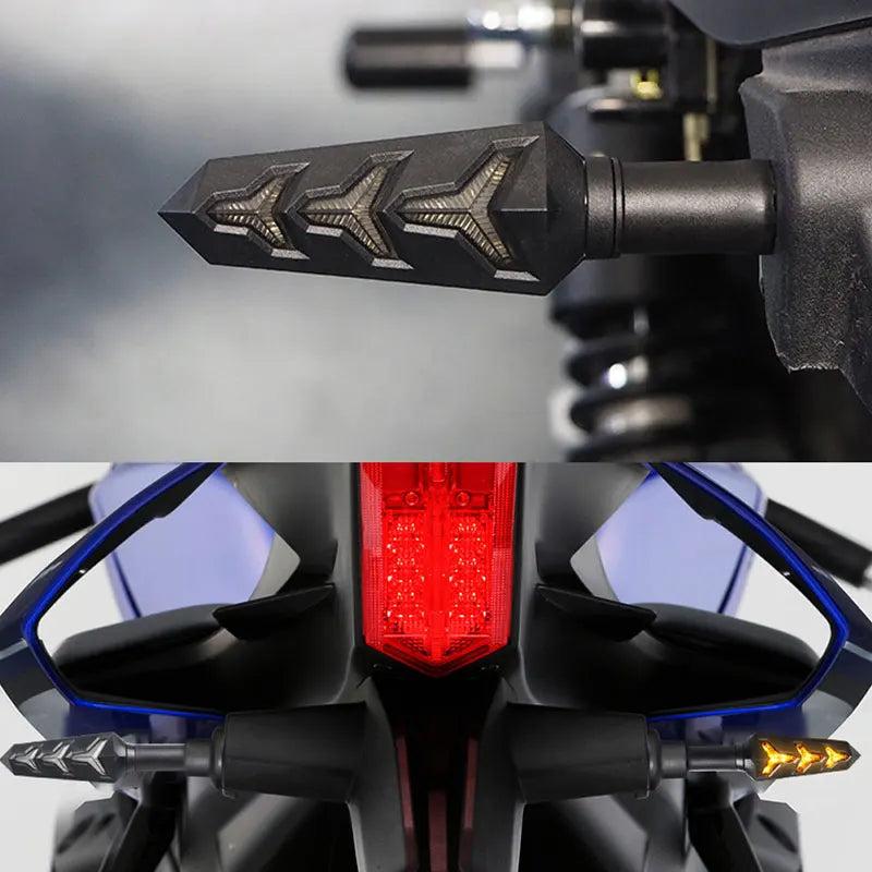 Close-up of motorcycle turn signals featuring a black housing and amber LED light.