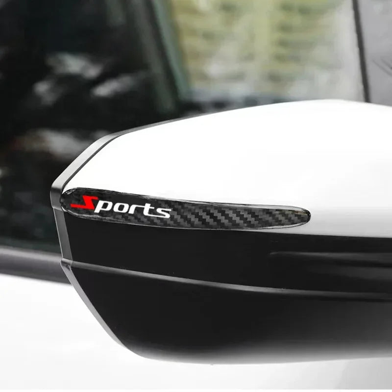 Close-up of a black car door handle with a black carbon fiber scratch protection kit installed.