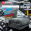 A bag of microfiber car wash dry cloths and a stack of dark gray microfiber towels on a wet car hood.