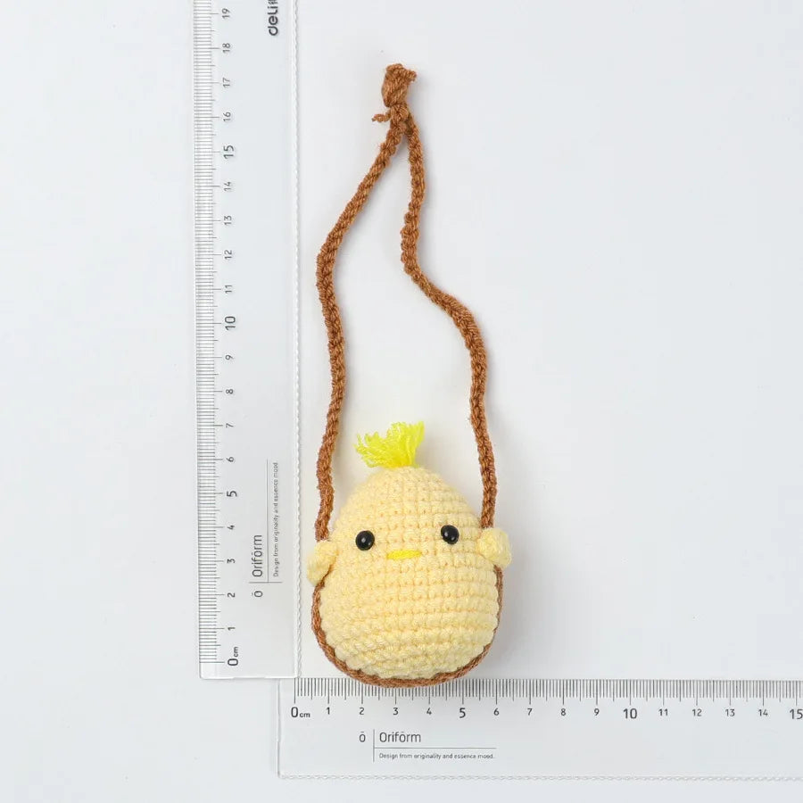 A yellow crochet hanging duck decor is shown next to a ruler.