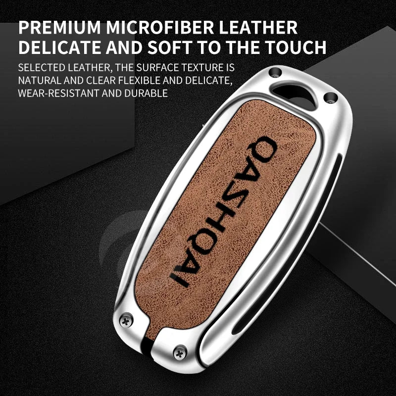 A close-up view of a premium microfiber leather car key cover with the name QASHQAI embossed on it.