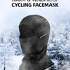 A black cycling facemask is shown against a snowy, winter outdoor background.