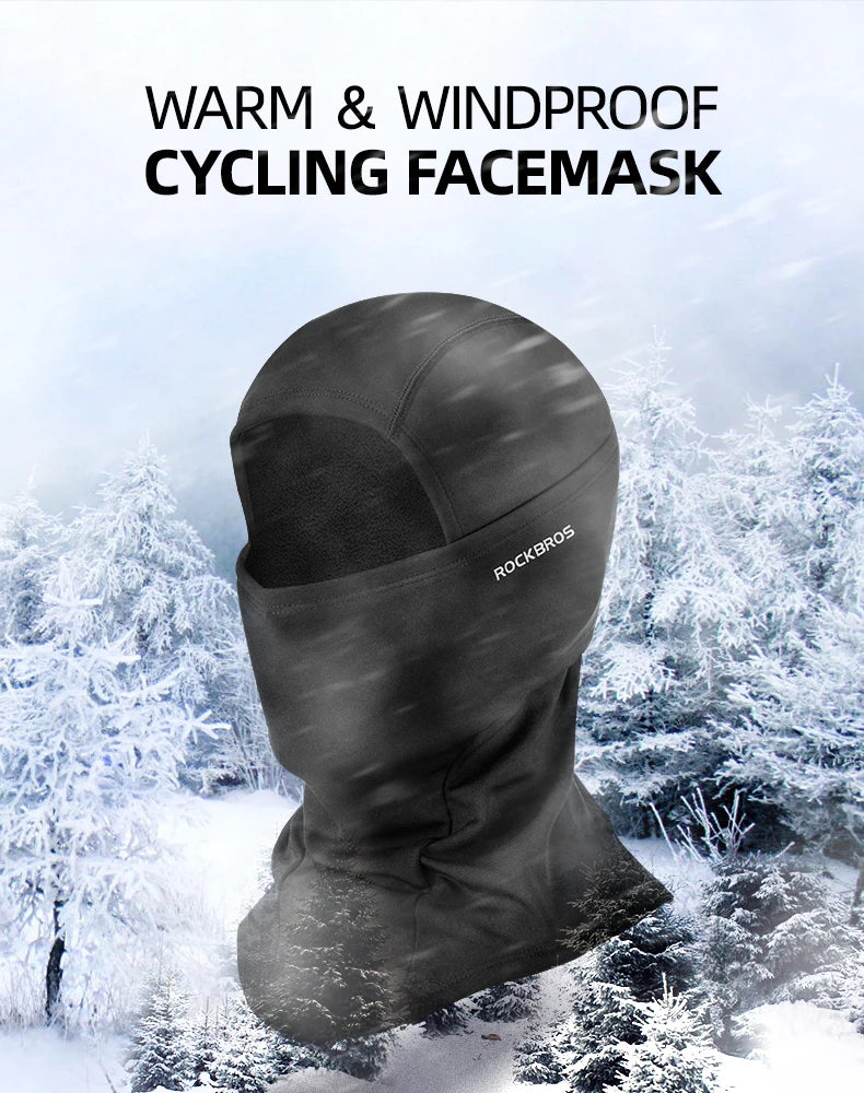 A black cycling facemask is shown against a snowy, winter outdoor background.