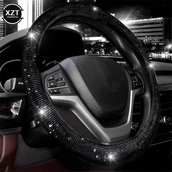 A close-up view of a black steering wheel covered in sparkling crystal rhinestones.