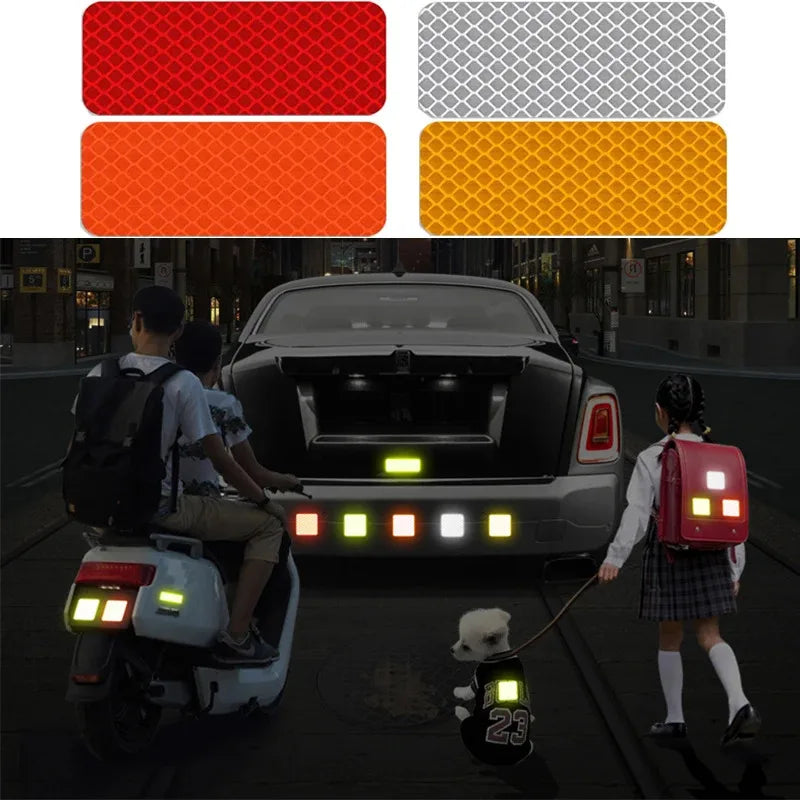 Une personne conduit un scooter avec un autocollant de sécurité réfléchissant sur le pare-chocs d'une voiture sombre.