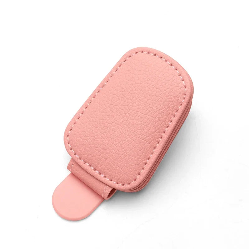 A pink magnetic leather sunglasses holder designed for car sun visors.