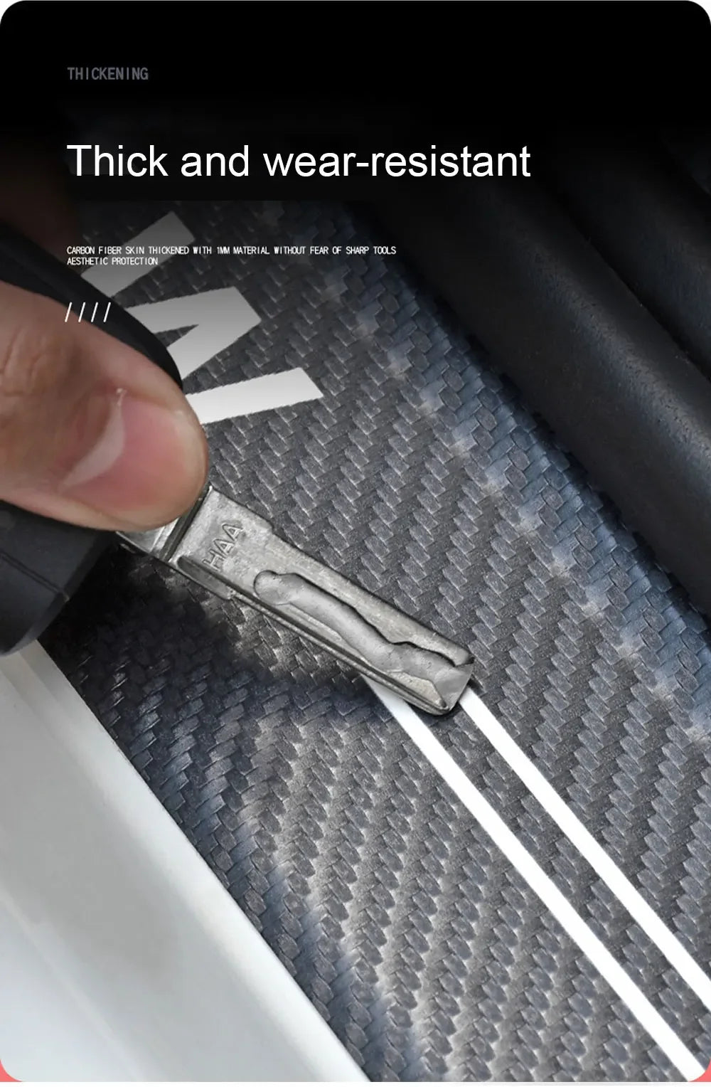 A close-up of a thick, metallic door sill protector resting on a textured black surface.