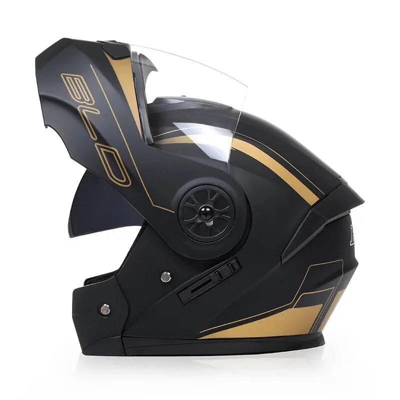 A black motorcycle helmet with a clear visor and gold accents is shown from the side.