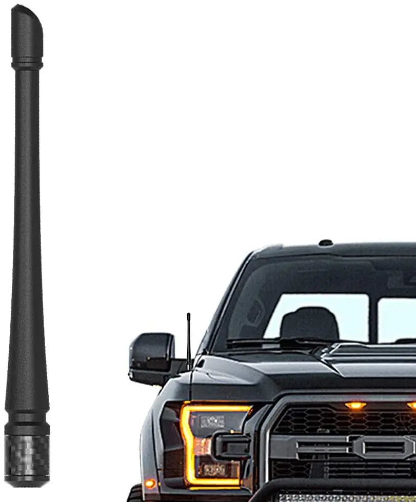 A black universal car antenna is shown next to a black pickup truck grille.
