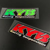 Two rectangular decals featuring the KYB Racing Suspensions logo in green and red on a black background.