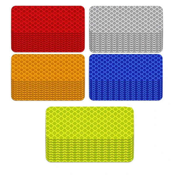 Una colección de cuatro pegatinas reflectantes de advertencia en rojo, gris, azul y amarillo.