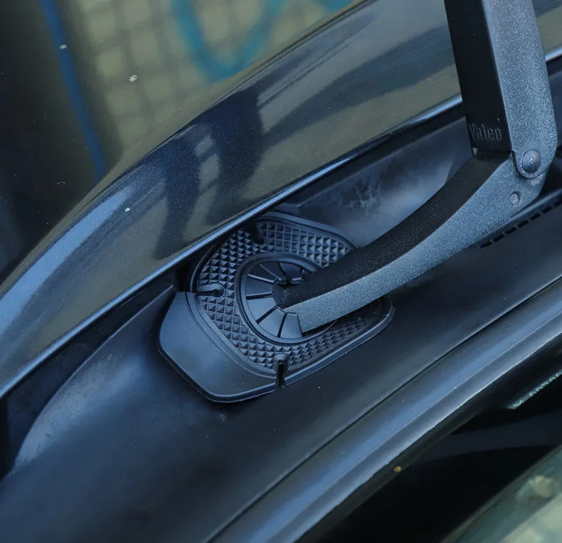 A close-up view of a black universal windshield wiper protective cover attached to a vehicle's wiper arm.