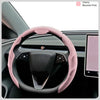 A pink breathable perforated leather steering wheel cover is shown in a car interior with a tablet visible.