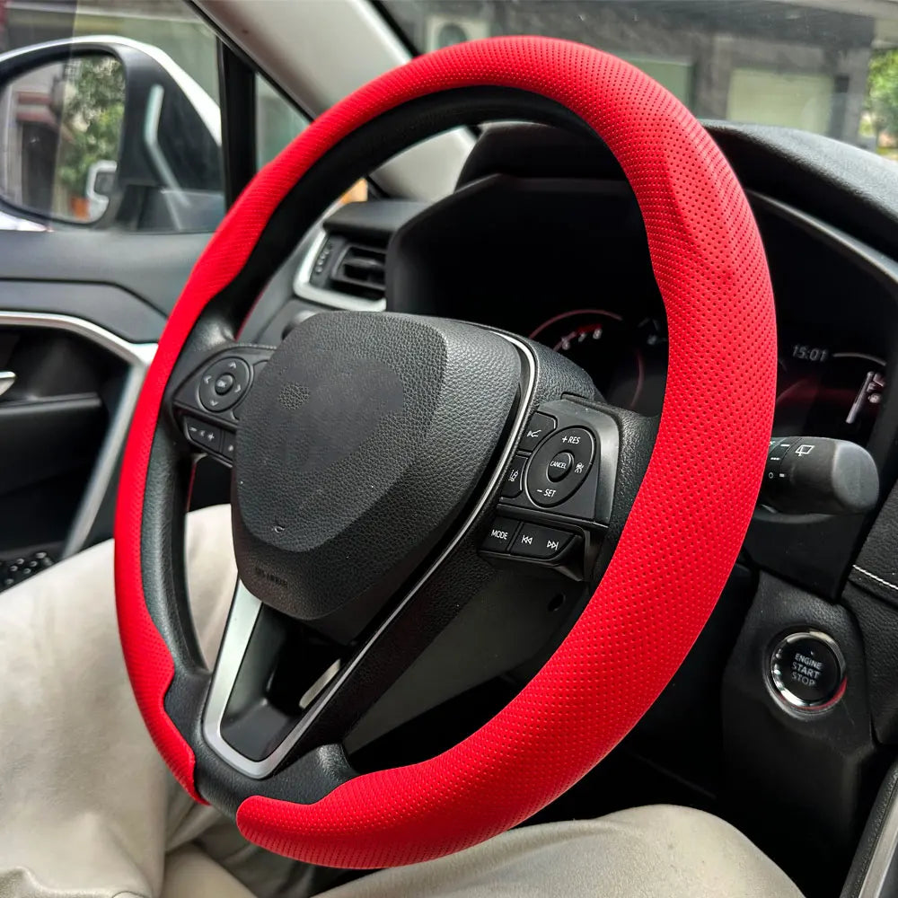 Nahaufnahme einer roten Leder-Lenkradabdeckung, installiert auf dem Lenkrad eines Autos.