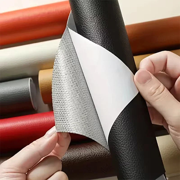 A hand is peeling a gray self-adhesive PU leather repair patch from a black leather surface.