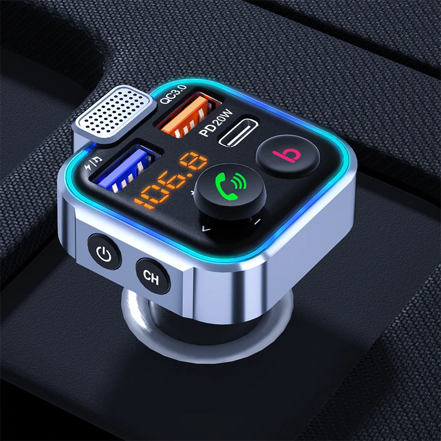 A silver Bluetooth car audio transmitter with a USB port, power indicator, and charging port is shown on a black surface.