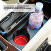 A clear plastic water cup is placed in a specialized holder within a car's interior console.