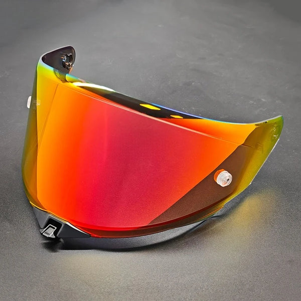 A replacement motorcycle helmet visor with a gradient of orange and red tint is shown on a dark surface.