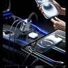 A hand is using a flexible retractable cable car charger to simultaneously charge four devices in a car.