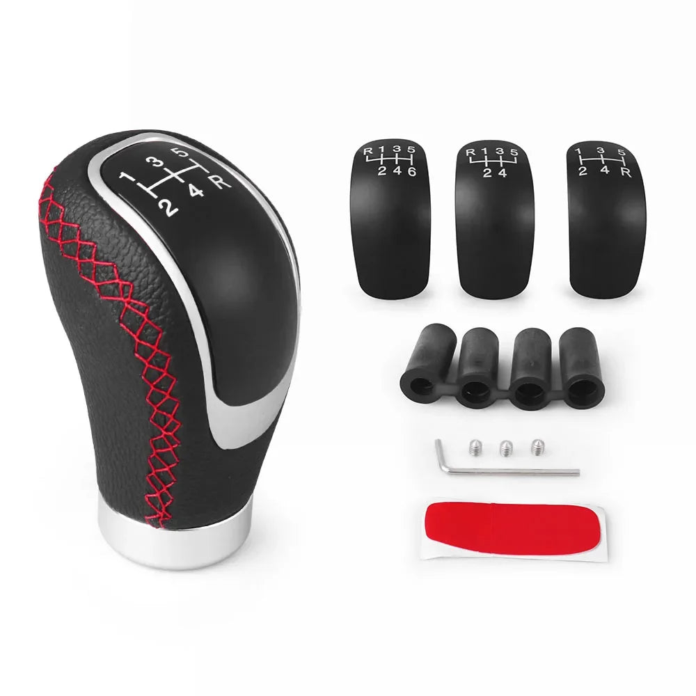 A black manual gear shift knob with a silver base and interchangeable speed covers shown next to the main knob.