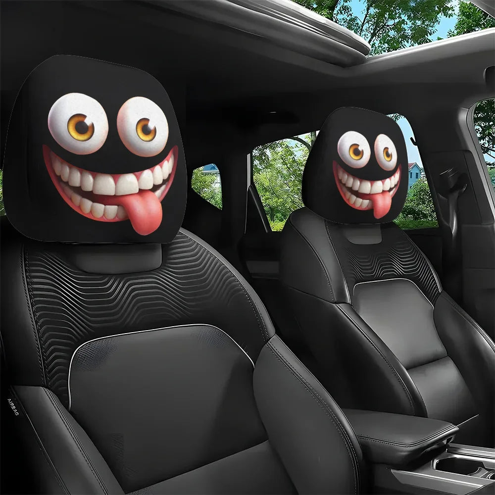 A pair of funny cartoon car headrest covers with big eyes and tongue-out designs installed in a black car interior.