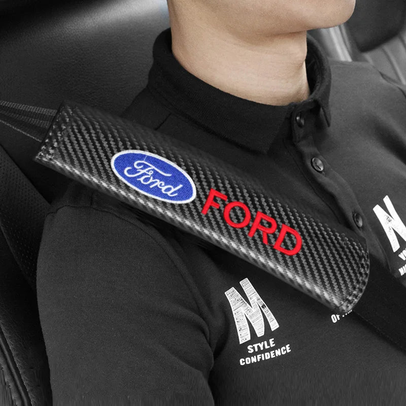A black shirt features a Ford logo and a carbon fiber seat belt shoulder pad cover.