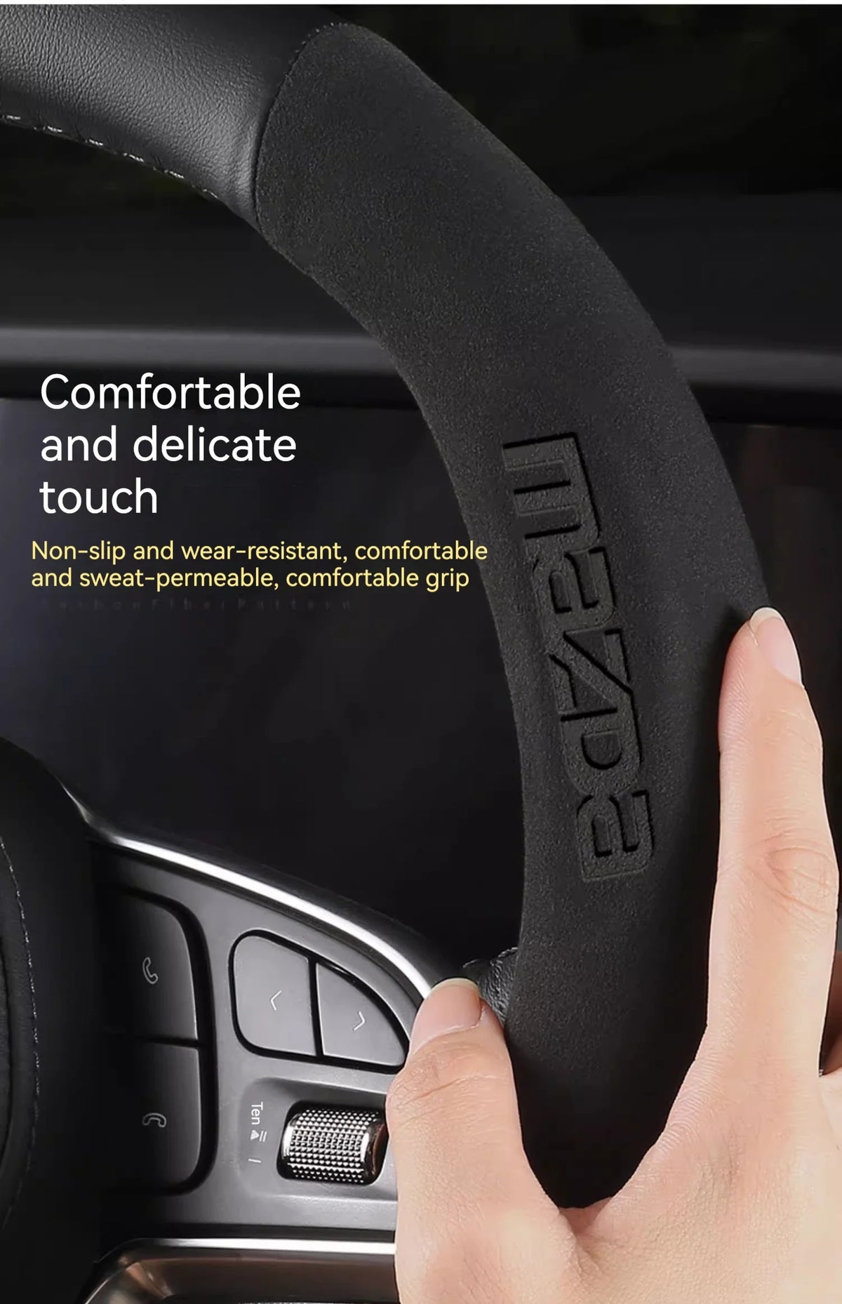 Une main tient une housse de volant en fibre de carbone noire pour une voiture Mazda.