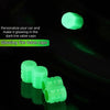 Gros plan sur des bouchons de valve de pneu vert lime lumineux illuminant un fond sombre.