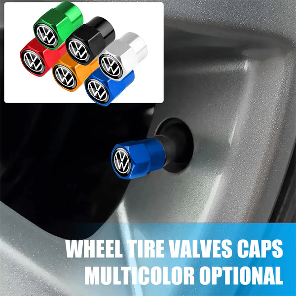 A set of multi-color metal tire valve caps in green, black, silver, orange, and blue displayed against a car wheel.
