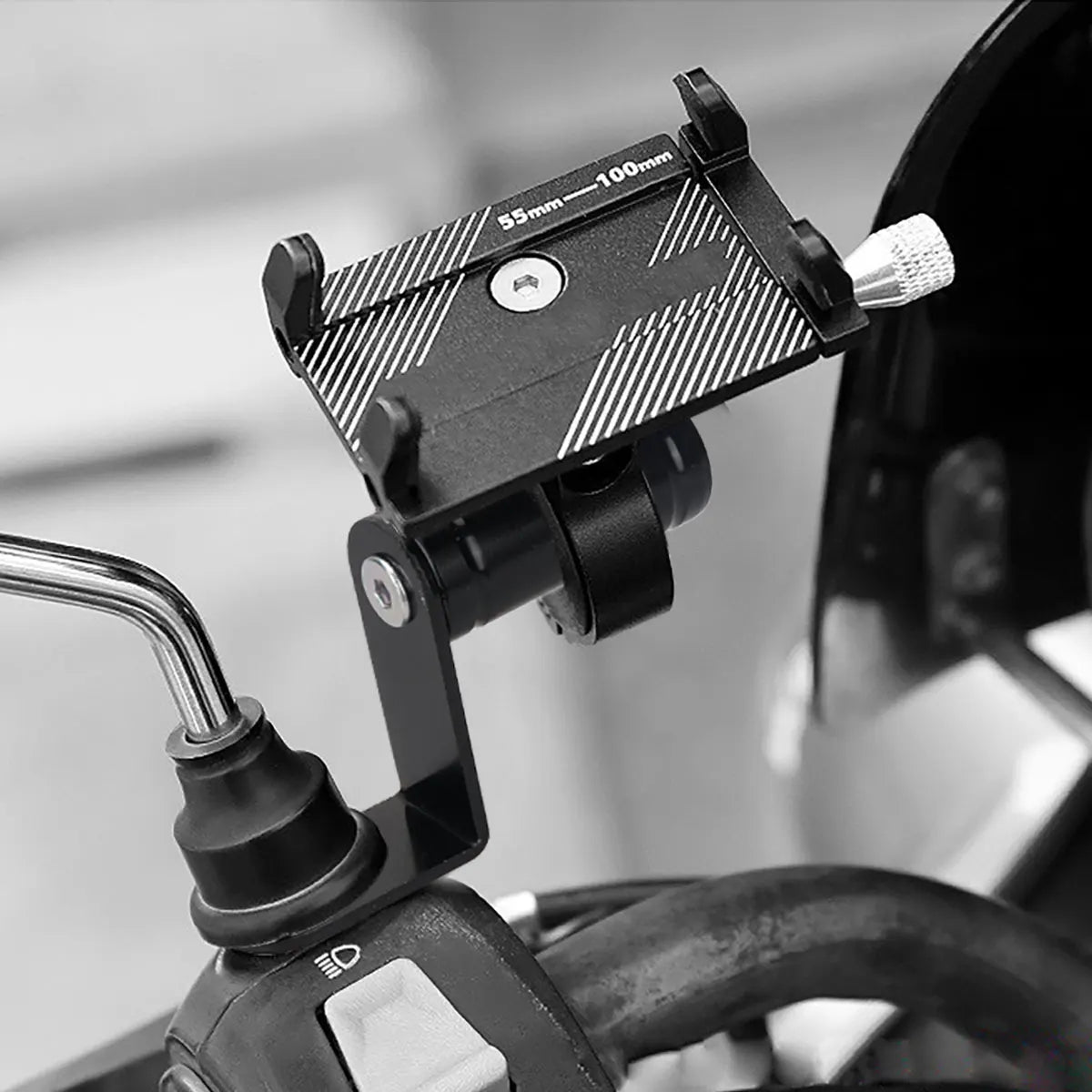 A black universal phone holder is mounted on a bicycle handlebar, designed for use with motorcycles and bicycles.