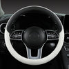 Close-up view of a black steering wheel with a white leather cover and silver accents inside a car interior.