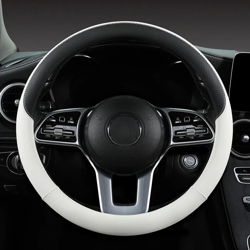 Close-up view of a black steering wheel with a white leather cover and silver accents inside a car interior.