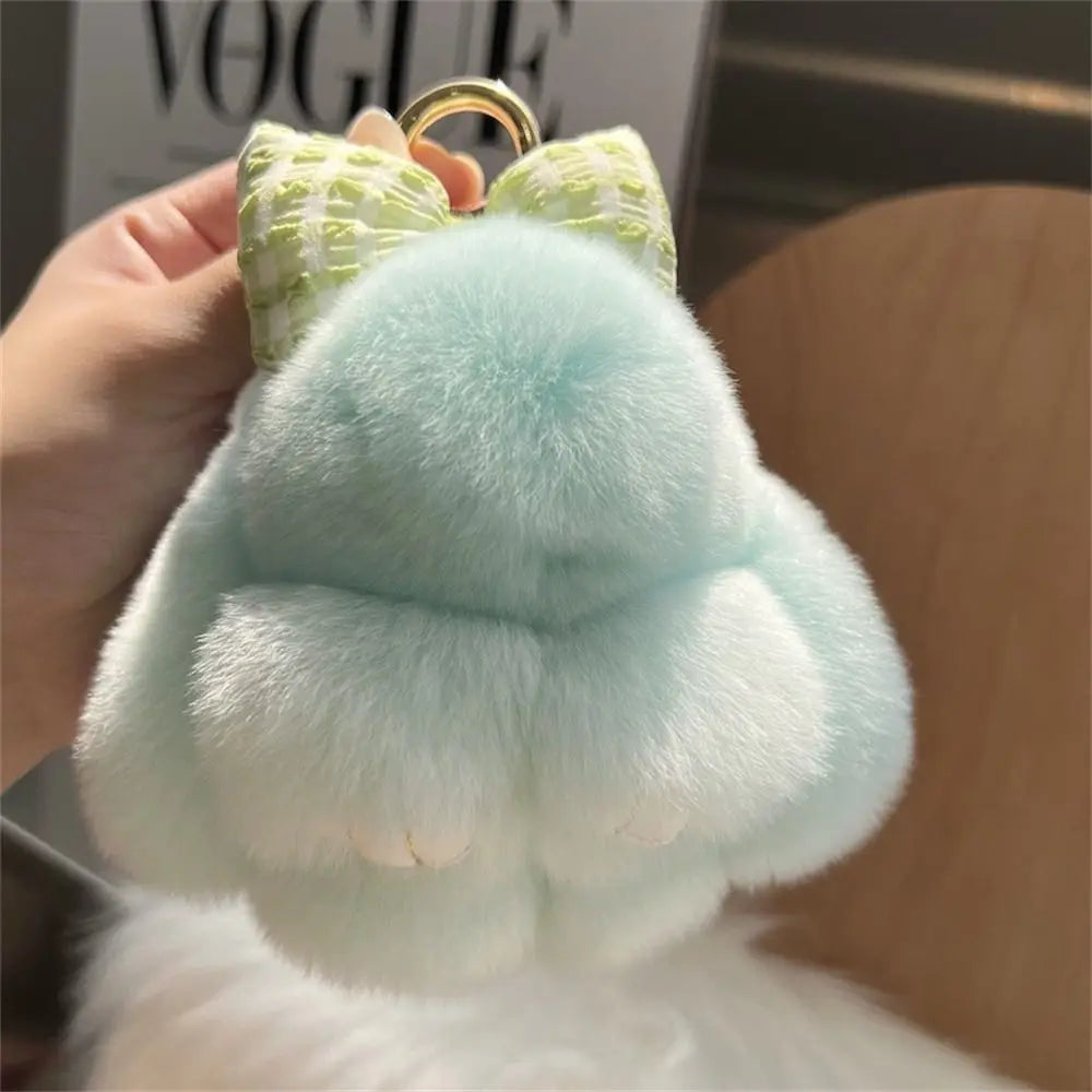 Light blue plush bunny keychain with soft fur and a gold ring