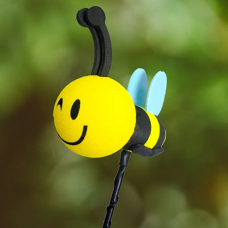 A yellow bee-shaped antenna decoration with black and light blue wings.