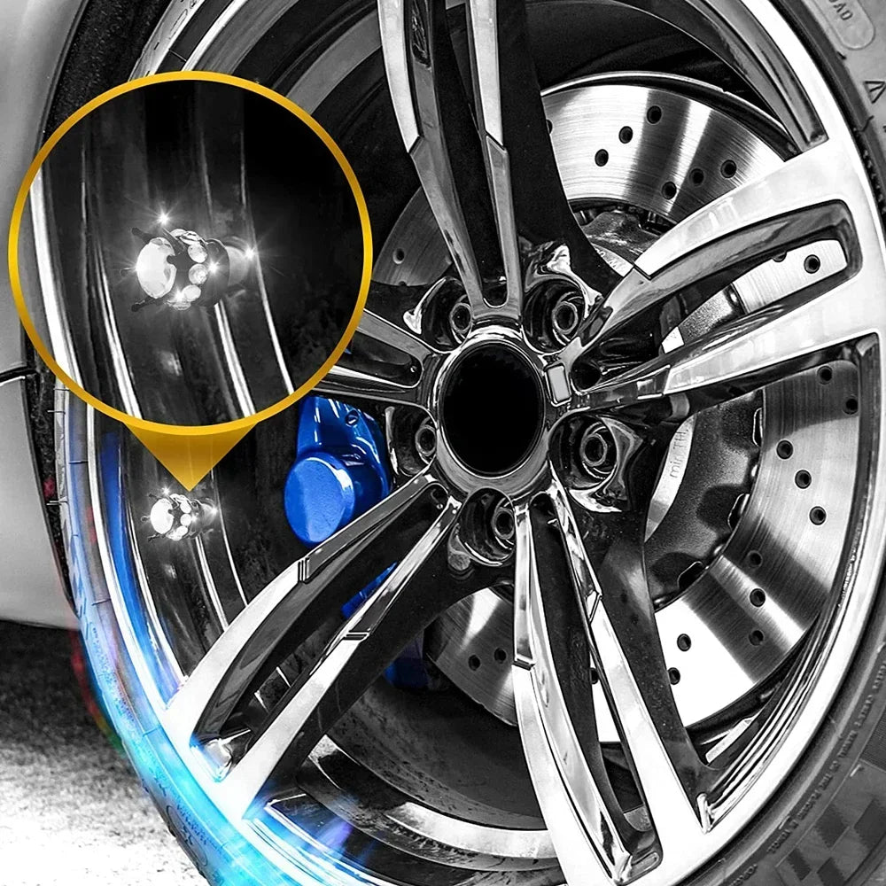 Close-up view of a diamond rhinestone tire valve caps set installed on a metallic wheel rim.