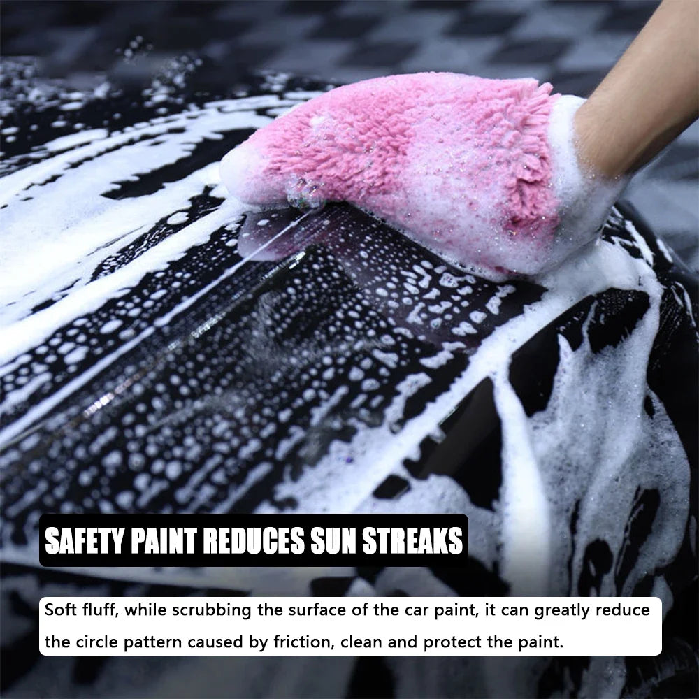 A hand wearing a pink microfiber glove is cleaning paint on a black car surface, reducing sun streaks.
