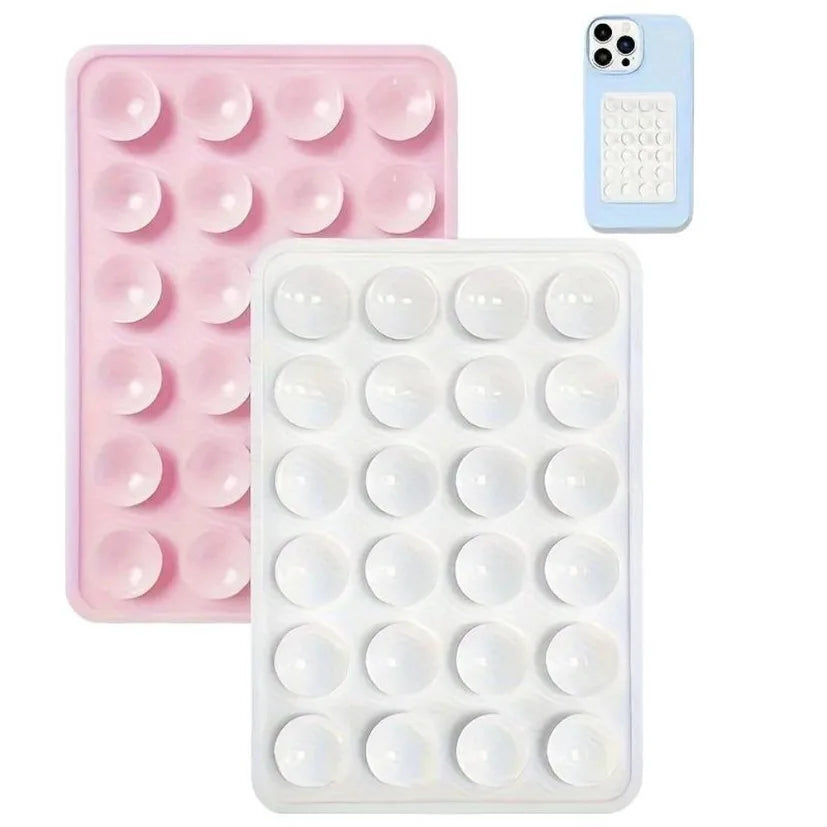 Un support de téléphone en silicone rose et un support en silicone blanc sont montrés à côté d'un smartphone bleu clair.