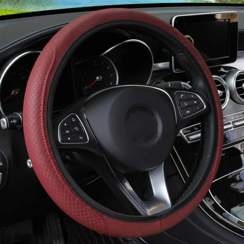 A close-up view of a red leather steering wheel cover inside a car, showing the steering wheel and dashboard details.
