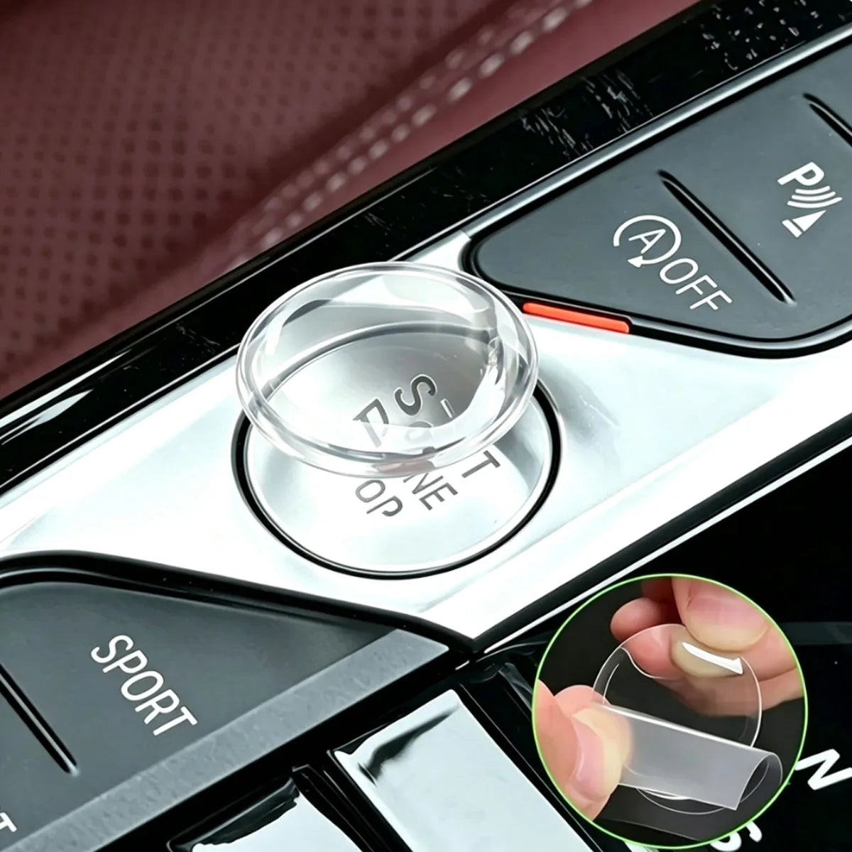 A close-up of a crystal clear ignition button protector installed on a car dashboard.