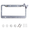 Silver decorative license plate frame with a bow accent and mounting hardware.