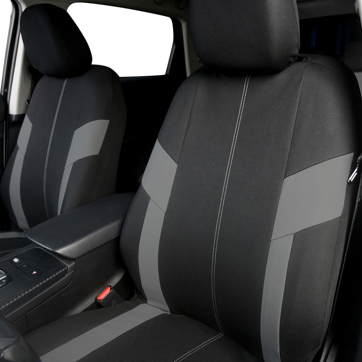 Gros plan d'un siège de voiture noir avec des accents et des coutures grises, montrant la texture du revêtement.