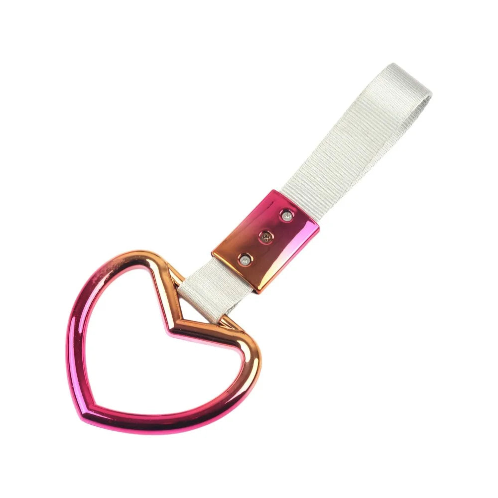A holographic heart-shaped car handle accessory with a white strap and rose gold accents.