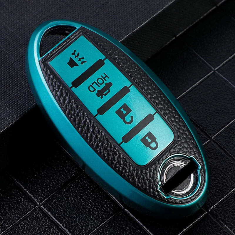 A teal car key fob cover with a black textured surface and multiple buttons resting on a dark background.