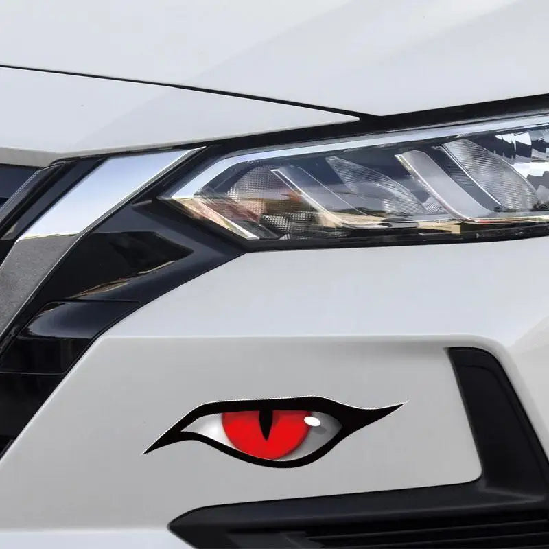 Nahaufnahme eines weißen Auto-Scheinwerfers mit schwarzem Design und einem roten Tierauge-Emblem.
