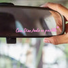 A hand holds a black car mirror with a pink heart decal that reads Con Dios todo es posible