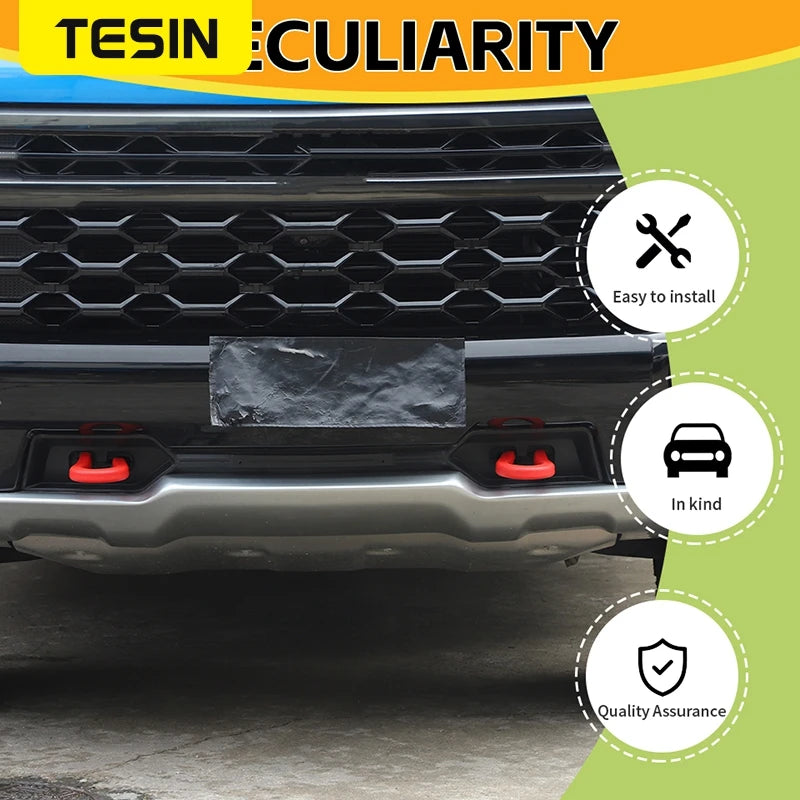 A black universal car exterior bumper tow hook cover installed on a vehicle grille and bumper.