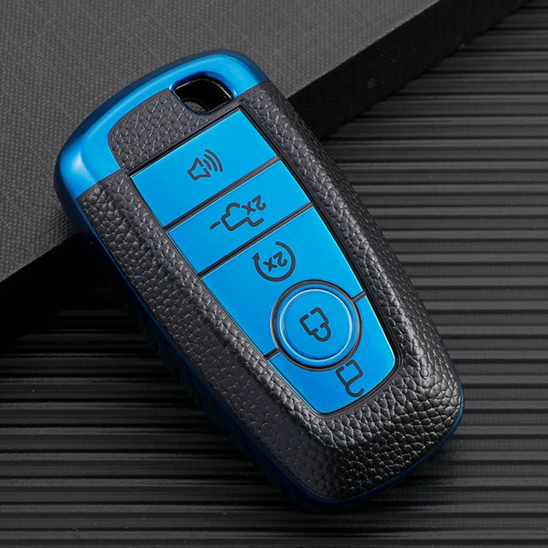 A blue multi-function key fob holder with four buttons resting on a dark surface.