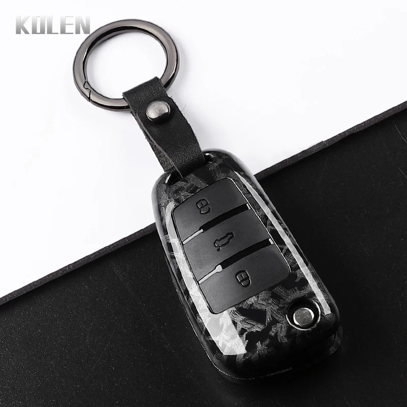 A black carbon fiber car key case cover with a metal keyring attached.
